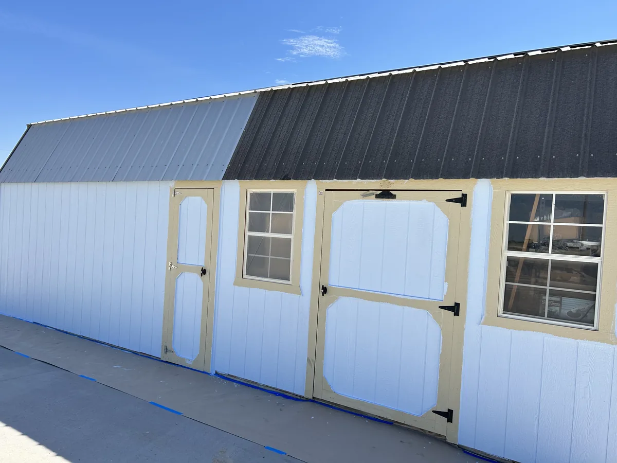 Metal storage building with faded trim before painting