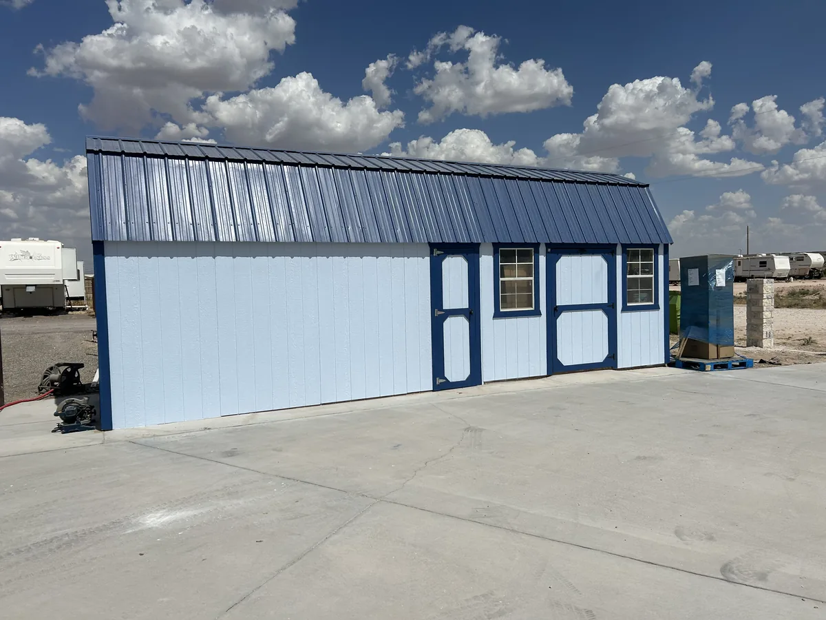 Metal storage building painted light blue with dark blue trim around the doors and windows