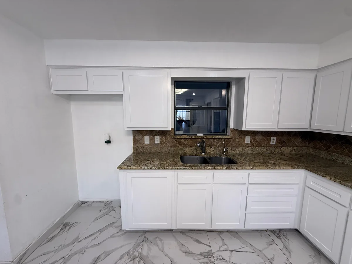 Kitchen sink wall with white painted cabinets
